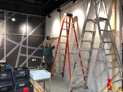 two workers in a retail construction site with ladders | QTC Retail Solutions